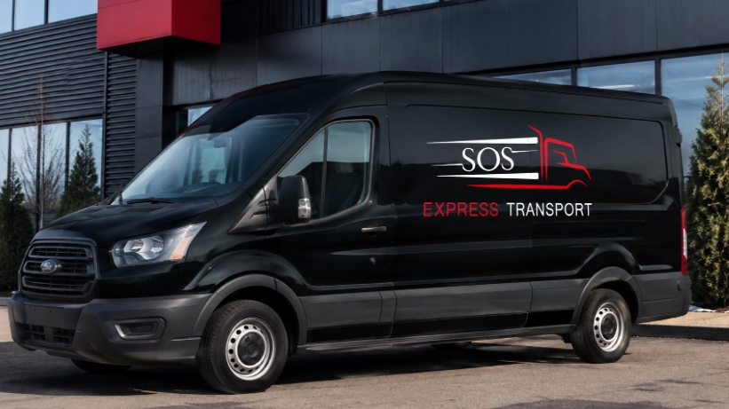 Camionnette noire identifiée SOS Express Transport devant un bâtiment commercial.